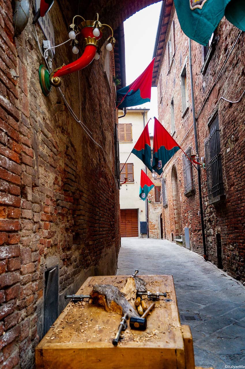 I suggestivi vicoli di Torrita di Siena con le bandiere delle contrade