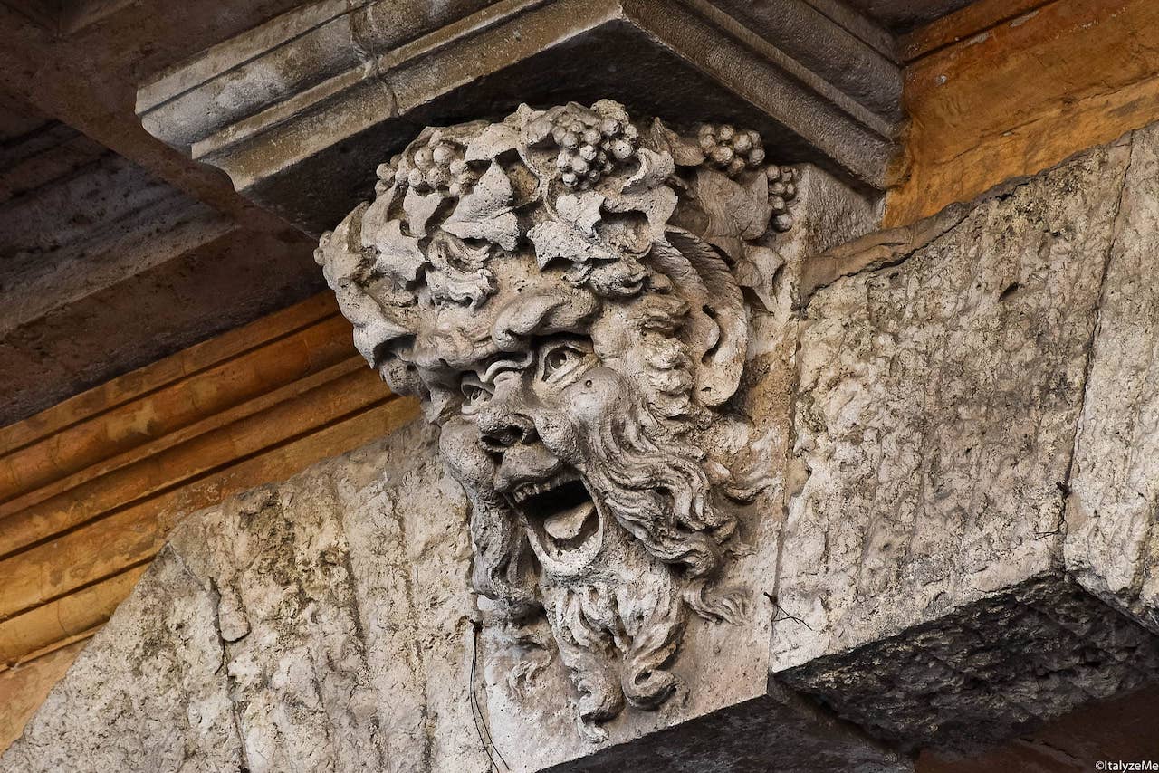 Il dio del vino Bacco sorveglia con espressione estatica un portone nel centro storico di Orvieto